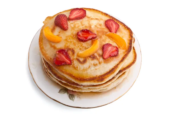 Stack of pancakes with syrup and fruit on a plate — Stock Photo, Image