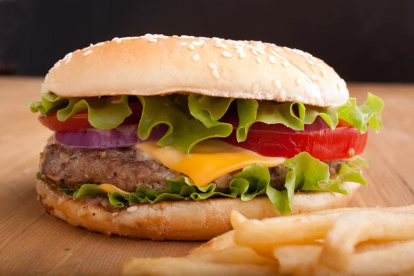Çizburger ve patates kızartması bir ahşap tablo — Stok fotoğraf