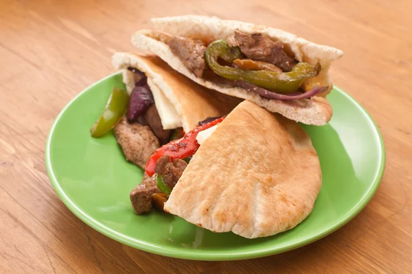 Três metades de sanduíches de pão de pita com carne e legumes — Fotografia de Stock