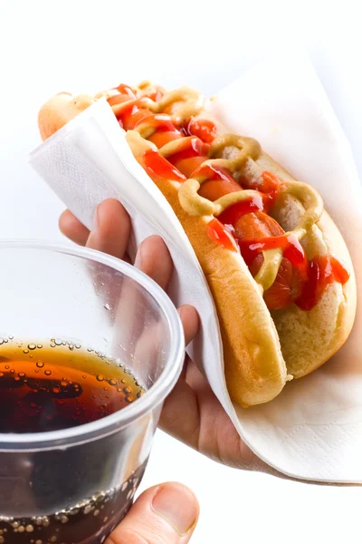 Hot dog con senape e ketchup e cola in mano — Foto Stock