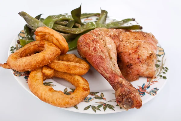 Chicken leg with green beans and onion rings — Stock Photo, Image