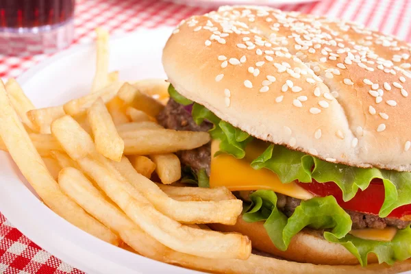 Cheeseburger, Franse frietjes en cola op een kunststof plaat — Stockfoto