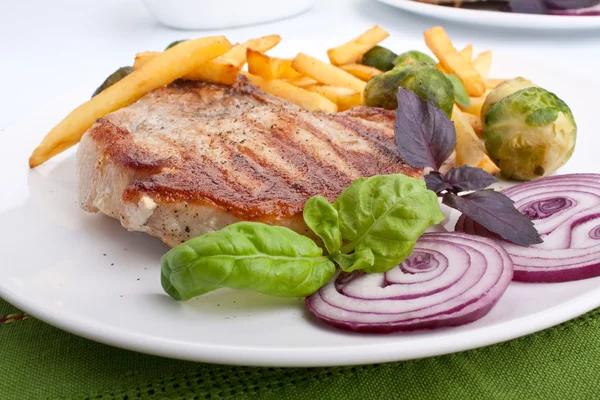 Pork chops with fries and brussels sprouts — Stock Photo, Image