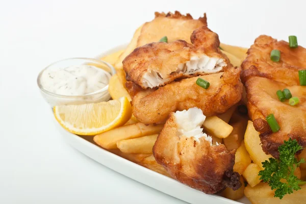 Рыба и чипсы на тарелке на белом фоне — стоковое фото