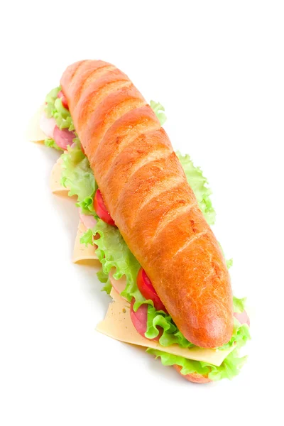 Um longo sanduíche de baguete com alface, fatias de tomate fresco — Fotografia de Stock