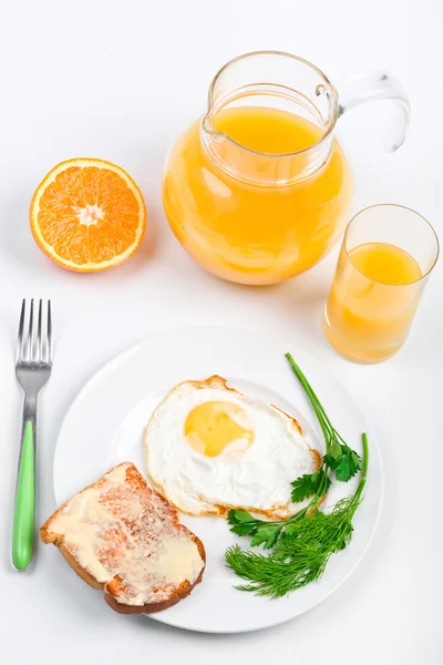 Fried egg and a jug of orange juice — Stock Photo, Image