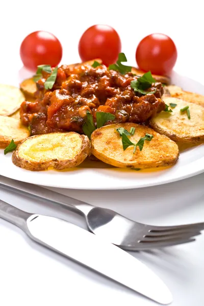 Geroosterde land-stijl aardappelen met vlees tomatensaus — Stockfoto