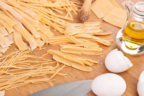 Diferentes tipos de pasta casera de huevo sin cocer en un jabalí de corte — Foto de Stock