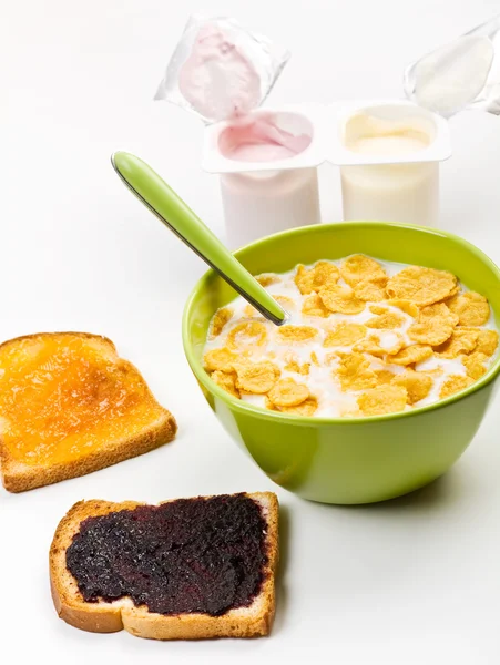 Bowl of milk with cereal, two toasts with spreaded jam and yougu — Stock Photo, Image