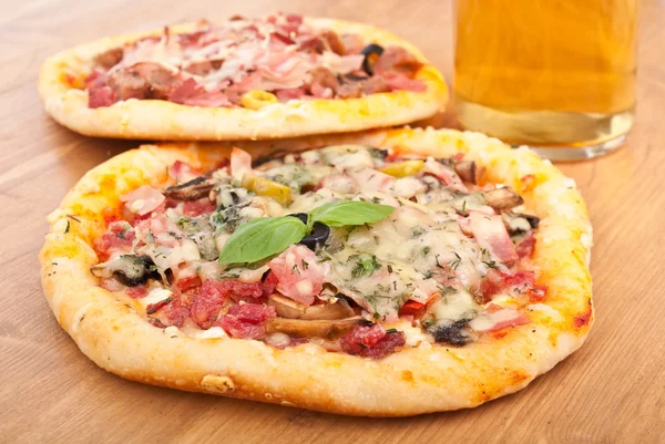two pizzas and a glass of beer
