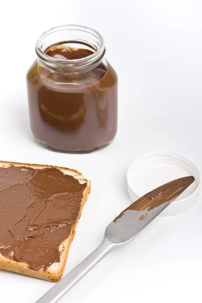 Chocolate spread container with a buttered toast — Stock Photo, Image