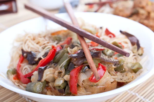 Rice noodles with vegetables and pair of chopsticks — Stock Photo, Image