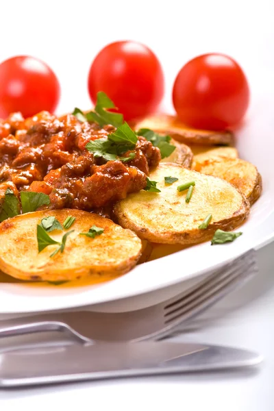 Roasted country-styled potatoes with meat tomato sauce — Stock Photo, Image