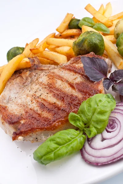 Pork chops with fries and brussels sprouts — Stock Photo, Image