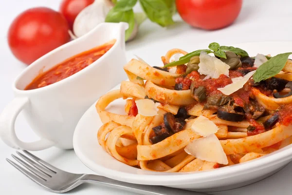 Linguine pasta with fresh tomato puttanesca sauce, cheese and ba — Stock Photo, Image