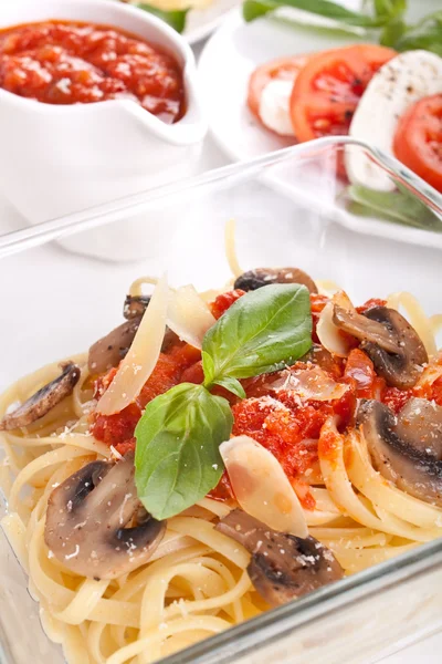 A bowl of pasta linguine with mushrooms, tomato sauce and parmes — Stock Photo, Image