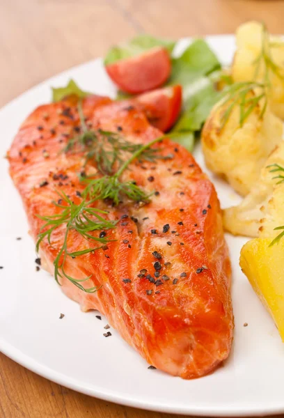 Plate with tasty  salmon garnished with vegetables — Stock Photo, Image