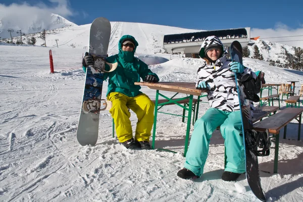 Två glada ungdomar med snowboards Stockbild