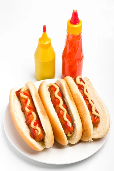 Three classic hotdogs with mustard and ketchup on a plate with k — Stock Photo, Image