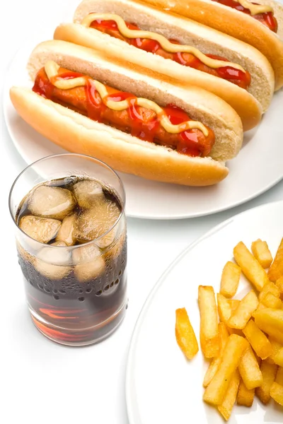 Bicchiere di cola, patatine fritte e tre hot dog — Foto Stock