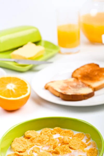 Bowl of cornflakes with milk, two buttered toas — Stock Photo, Image