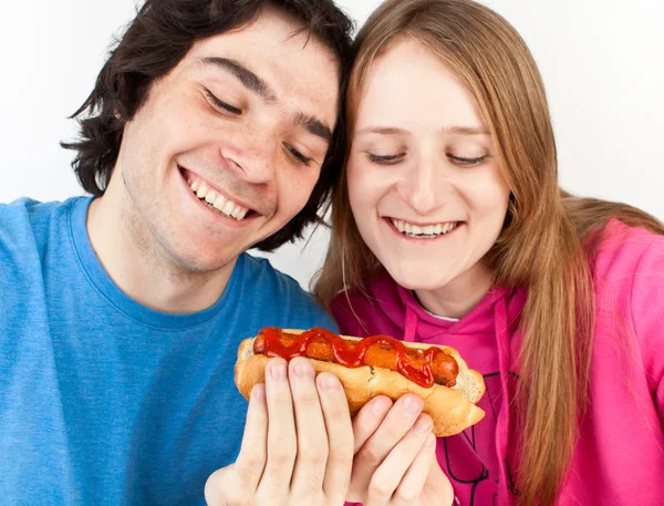 Casal segurando cachorro quente — Fotografia de Stock