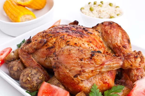 Pollo asado dorado entero con patatas asadas, tomate fresco — Foto de Stock