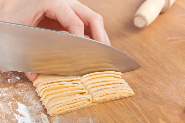 cutting uncooked homemade egg pasta