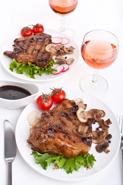 Porties van pork chop met paddestoelen en groenten — Stockfoto