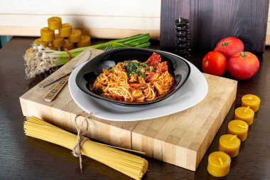 domatesli makarna, soğan ve otlar, balmumu mumlarının arka planına karşı