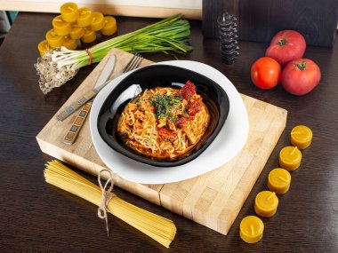 domatesli makarna, soğan ve otlar, balmumu mumlarının arka planına karşı