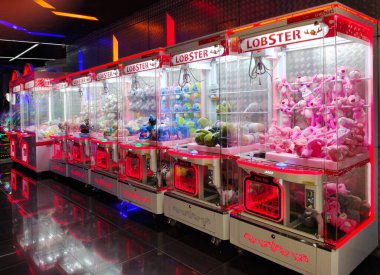 Kuala Lumpur, Malezya - 25 Nisan 2022: İnsanların oyuncakları ve diğer ödülleri kazanabileceği renkli atari oyuncakları oyuncak vinç makinesi, Kuala Lumpur.