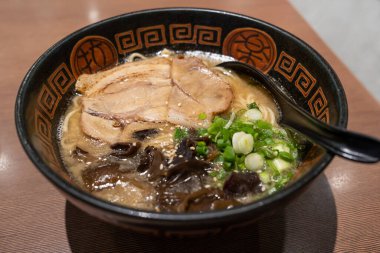 Japon ramen çorbasının yakından görüntüsü, tavuk, soğan ve mantar ile ahşap masada..