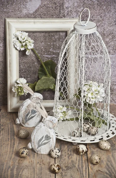 Pasqua, uova in gabbia, fiori bianchi primaverili, uova di quaglia, coniglietti bianchi — Foto Stock