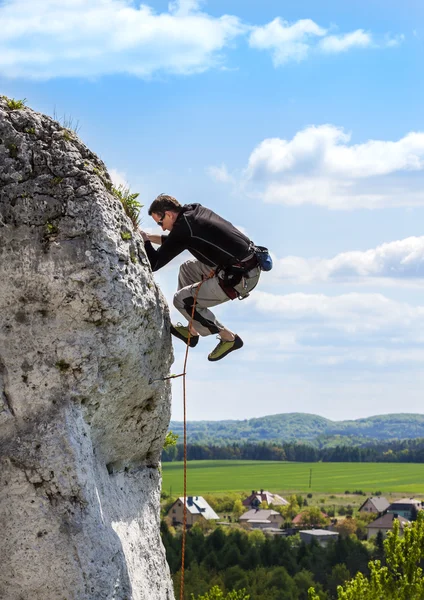 Escalada extrema en roca, hombre en la pared natural con cielo azul . —  Fotos de Stock