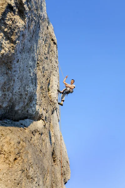 Escalada de rocha extrema, homem na parede natural com céu azul . — Fotografia de Stock
