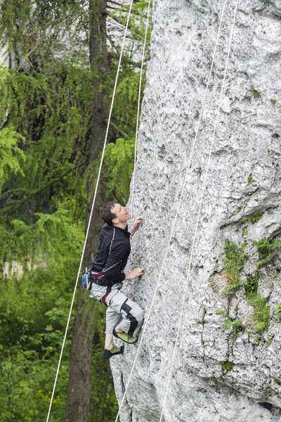 Man climbing steep and high rocky wall. — Stock Photo, Image