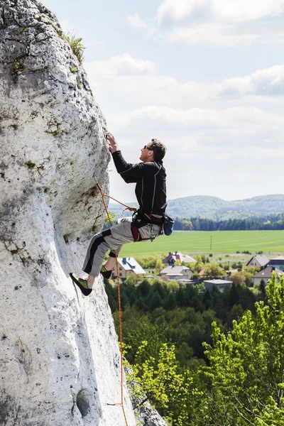 Hombre escalando pared rocosa difícil natural . — Foto de Stock