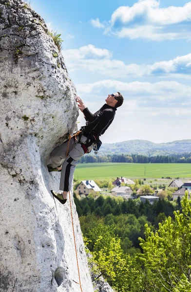 Uomo arrampicata parete rocciosa naturale con bella vista . — Foto Stock