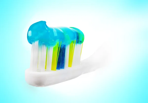 Зубная щетка с пастой на синем и белом фоне . — стоковое фото