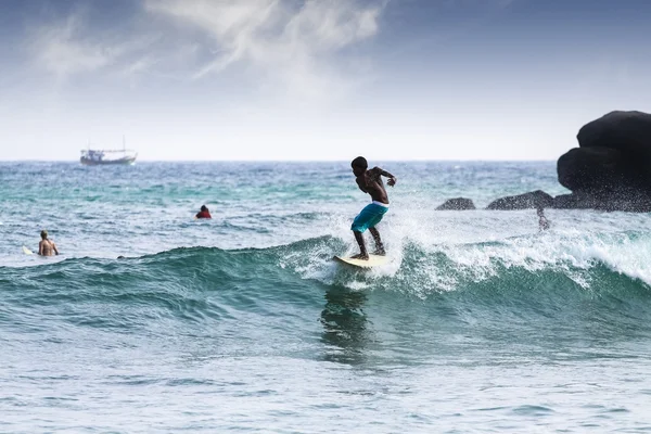 Silhouette fiatal fiú szörfözés a hullámok. — Stock Fotó