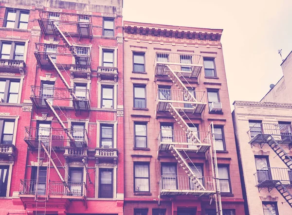 New York townhouses with fire escapes, color toning applied, USA.