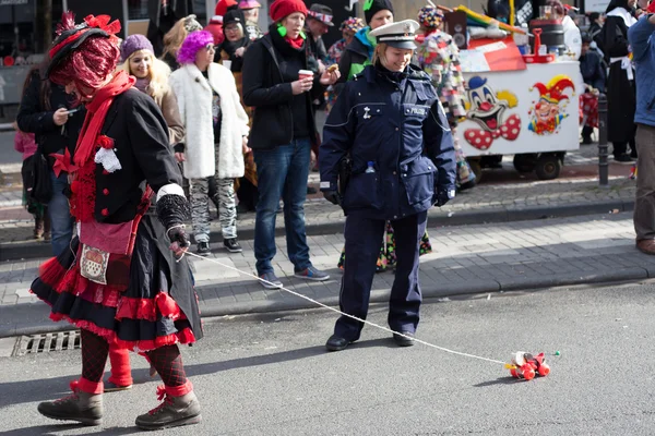 Female Police Officer looking at a toy on a carnival procession