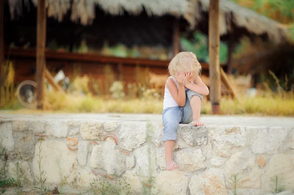 Little girl sitting on the curb — Stock Photo, Image