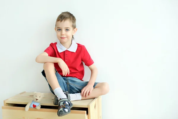 Boy sitting on the dresser — Stock Photo, Image