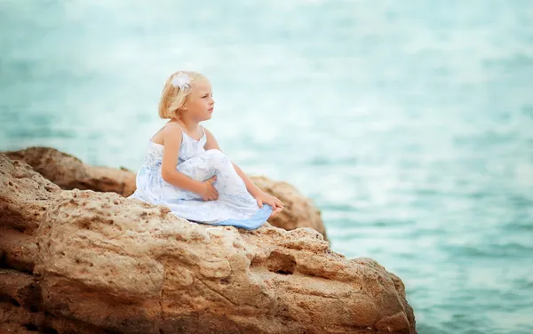 Маленькая девочка смотрит на море — стоковое фото