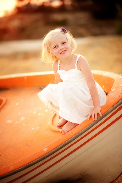 Petite jolie fille assise dans un bateau — Photo