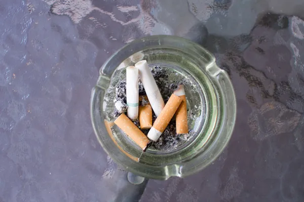 Obciążenie palenie papierosa w popielniczce — Zdjęcie stockowe