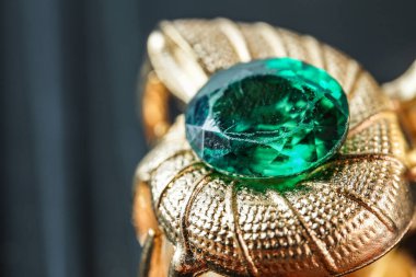 yeşil doğal değerli taş, parlak altın üzerinde mücevher veya mücevher