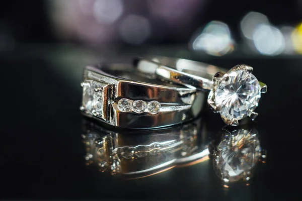 Designer wedding rings in the corner on a sparkling glitter background in panoramic banner format with copy space and selective focus